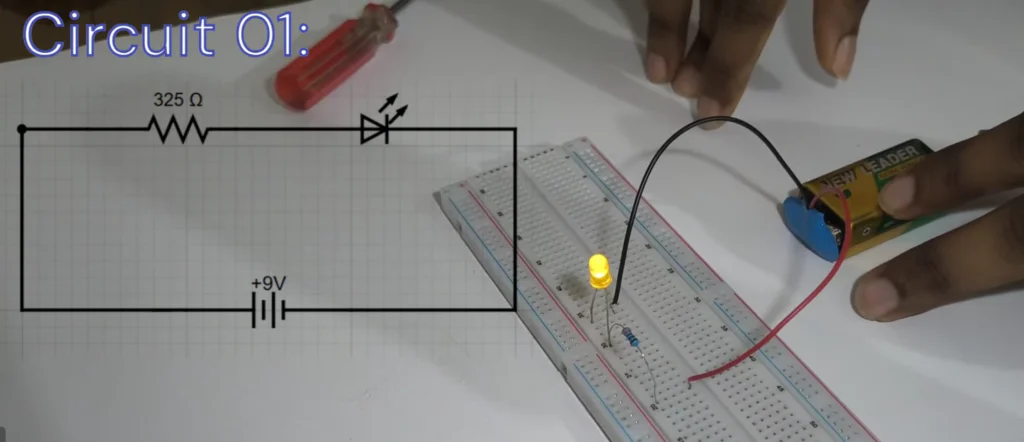 A side-by-side view of a 9V LED circuit schematic and its physical implementation on a breadboard with a yellow LED, resistor, and battery for a breadboard tutorial.